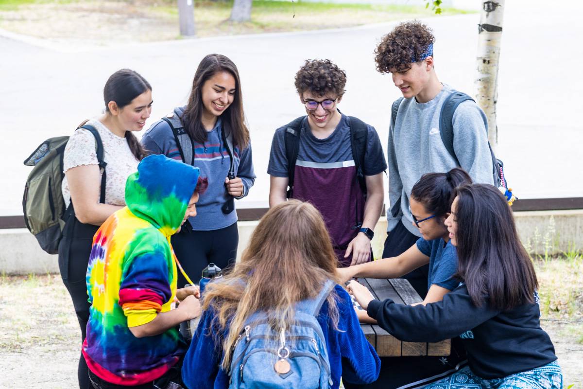 无码乱伦 Students gather at a picnic table outside the Wood Center on the Fairbanks Troth Yeddha' campus