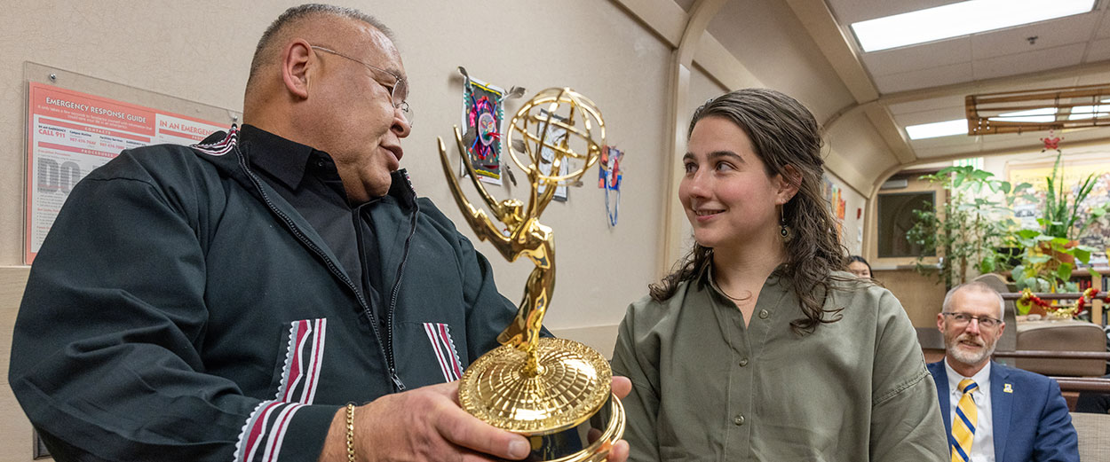 Maggie King and Walkie Charles pose with the Emmy Award as attendees enjoy the celebration during the ANLC Emmy Award Presentation and Celebration