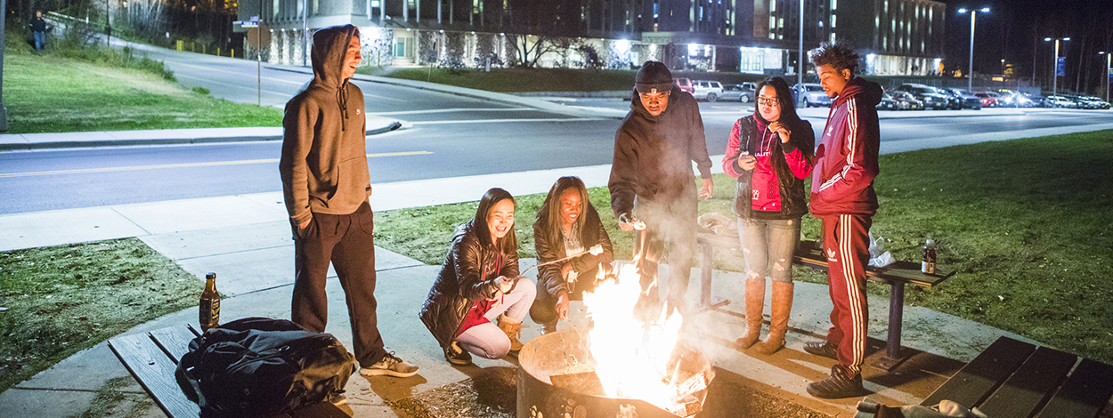 无码乱伦 students roast marshmallows around a fire pit on campus